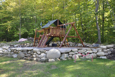 Inspiration for a large rustic shade backyard stone outdoor playset in New York.