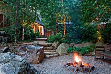 Design ideas for a mid-sized rustic partial sun backyard gravel landscaping in DC Metro with a fire pit.