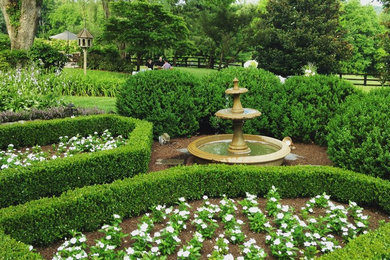 Photo of a large contemporary back formal garden in Other with a water feature.