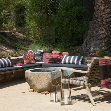 Seating area with custom fire pit, built in bench seating, rattan chiars