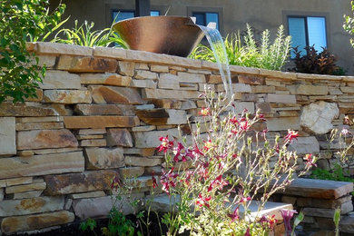 Exemple d'un jardin arrière chic de taille moyenne avec une exposition partiellement ombragée, des pavés en pierre naturelle et un point d'eau.