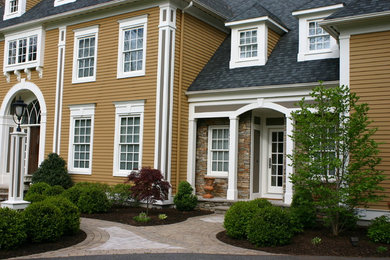 This is an example of a medium sized traditional front driveway partial sun garden for spring in Bridgeport with a garden path and brick paving.