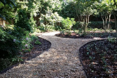 Photo of a large traditional shade backyard gravel landscaping in New Orleans.