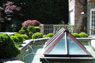 Immagine di un grande giardino formale chic dietro casa con fontane