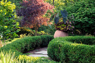 Diseño de camino de jardín tradicional en patio delantero con exposición parcial al sol, adoquines de piedra natural y jardín francés