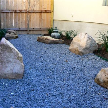 Side yard; Texas black gravel design with small boulders