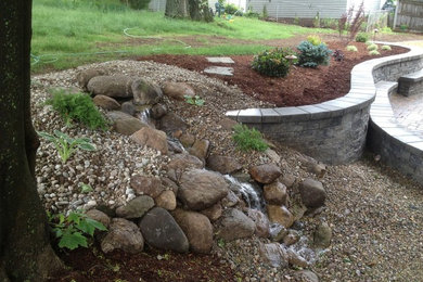 Design ideas for a large classic back partial sun garden in Boston with a retaining wall and gravel.