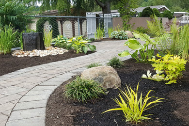 Photo of a medium sized contemporary back xeriscape partial sun garden in Seattle with a water feature and brick paving.
