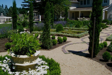 Ejemplo de jardín mediterráneo en patio trasero con jardín francés, exposición total al sol y gravilla