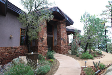 Photo of a large rustic partial sun front yard concrete paver landscaping in Phoenix.