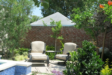 Diseño de jardín actual de tamaño medio en verano en patio trasero con exposición parcial al sol y adoquines de hormigón
