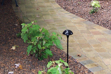 Imagen de jardín de estilo americano de tamaño medio en patio trasero con adoquines de piedra natural