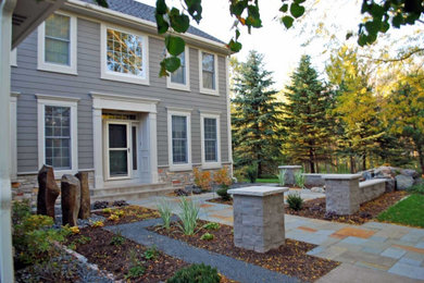 This is an example of a mid-sized traditional partial sun front yard stone walkway in Minneapolis for spring.