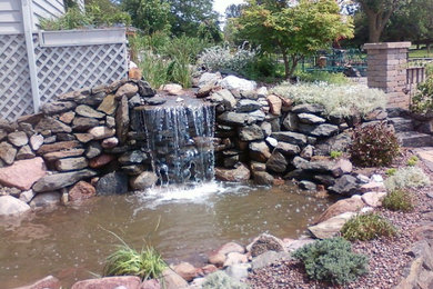 Medium sized back full sun garden in Chicago with a water feature and natural stone paving.