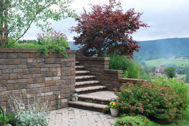 Photo of a traditional full sun hillside stone retaining wall landscape in Other for summer.