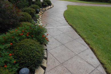 Cette photo montre un aménagement d'entrée ou allée de jardin avant tendance de taille moyenne avec des pavés en béton.