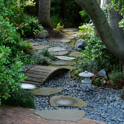 This is an example of a traditional shade backyard river rock water fountain landscape in San Francisco.