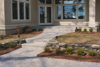 Photo of a mid-sized traditional partial sun front yard stone retaining wall landscape in Charlotte.