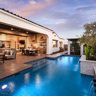 Großer, Halbschattiger Moderner Garten im Sommer, hinter dem Haus mit Kamin, Betonplatten und Metallzaun in Phoenix