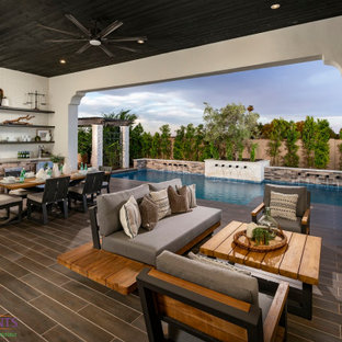 Großer, Halbschattiger Moderner Garten im Sommer, hinter dem Haus mit Kamin, Betonplatten und Metallzaun in Phoenix
