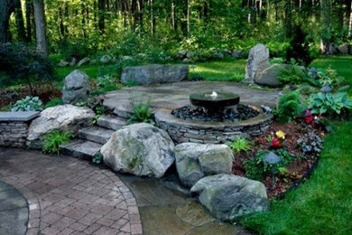 Idée de décoration pour un jardin tradition avec un point d'eau et des pavés en pierre naturelle.