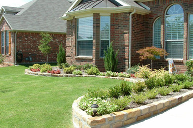 Photo of a mid-sized traditional full sun front yard lawn edging in Dallas.