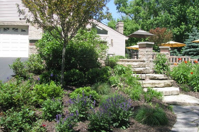 Diseño de jardín clásico renovado de tamaño medio en verano en patio trasero con jardín francés, muro de contención, exposición total al sol y adoquines de hormigón