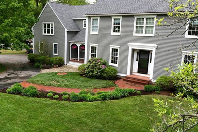 Photo of a large classic front driveway full sun garden in Boston with a garden path and brick paving.