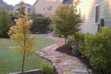 Design ideas for a large traditional partial sun side yard stone landscaping in Atlanta.