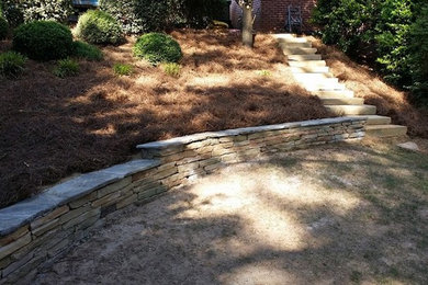 Design ideas for a backyard stone retaining wall landscape in Atlanta.