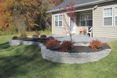 Photo of a mid-sized drought-tolerant and partial sun backyard stone landscaping in Philadelphia.