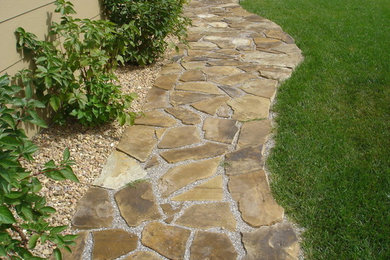 Front full sun garden in Wichita with a garden path and concrete paving.