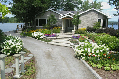 This is an example of a large mediterranean front driveway partial sun garden in Toronto with brick paving.