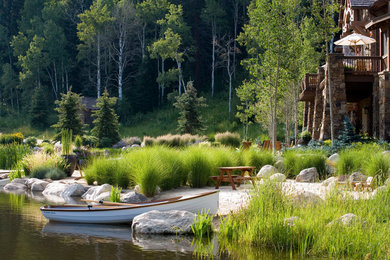 Design ideas for a rustic backyard stone water fountain landscape in Denver.