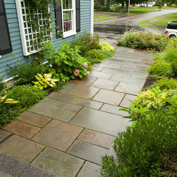 Streetward view of stone walkway bordered by plantings