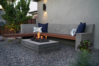 This is an example of a transitional drought-tolerant backyard gravel landscaping in Los Angeles with a fire pit.