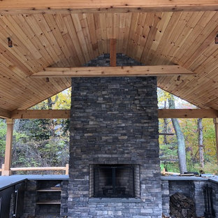 Halbschattiger Moderner Garten hinter dem Haus, im Sommer mit Kamin und Natursteinplatten in New York