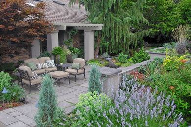 Photo of a mid-sized mediterranean partial sun front yard stone formal garden in Seattle with a fire pit for summer.