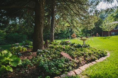 Imagen de jardín ecléctico grande en otoño en patio trasero con jardín francés y exposición parcial al sol