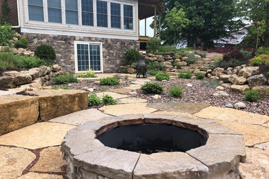 Design ideas for a large full sun backyard landscaping in Milwaukee with a fire pit.