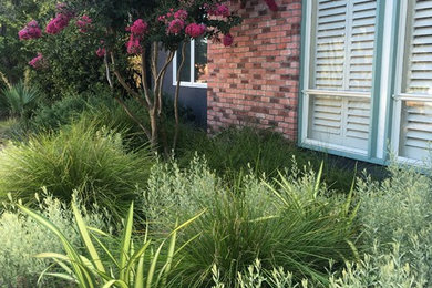 Diseño de jardín clásico de tamaño medio en patio delantero con exposición reducida al sol y gravilla