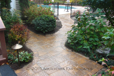 Photo of a contemporary back partial sun garden for summer in New York with a garden path and concrete paving.