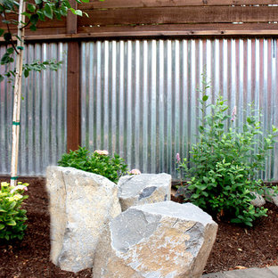 Inspiration for a mid-sized modern full sun backyard stone landscaping in Portland.