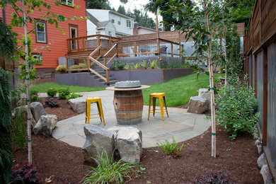 This is an example of a mid-sized modern full sun backyard stone landscaping in Portland.