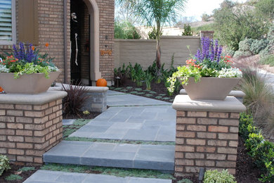 Modelo de jardín clásico renovado de tamaño medio en patio delantero con brasero, exposición parcial al sol y adoquines de piedra natural