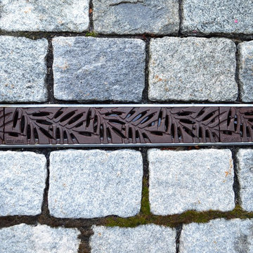 Tench drain cover with cobbled driveway apron strip.