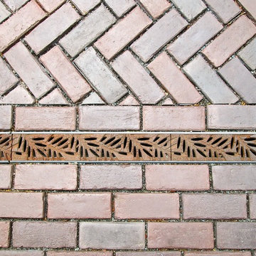 Tench drain cover with permeable brick pavers.