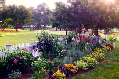 Ejemplo de jardín tradicional de tamaño medio en verano en patio trasero con exposición parcial al sol y mantillo