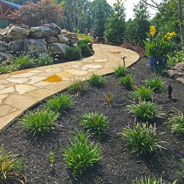 The backside of the pool showing landscaping and walkway made of flagstone.