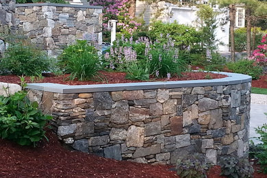Design ideas for a mid-sized traditional partial sun front yard mulch retaining wall landscape in Boston.